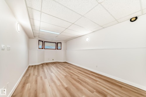 Empty room with a paneled ceiling and light wood-type flooring - 14063 128 Street, Edmonton, AB - Indoor Photo Showing Other Room
