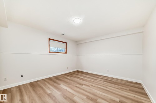 Unfurnished room featuring light wood-style floors and baseboards - 14063 128 Street, Edmonton, AB - Indoor Photo Showing Other Room