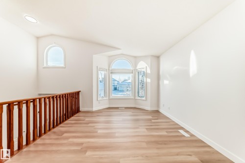 Spare room featuring healthy amount of natural light, light wood-style floors, and lofted ceiling - 14063 128 Street, Edmonton, AB - Indoor Photo Showing Other Room