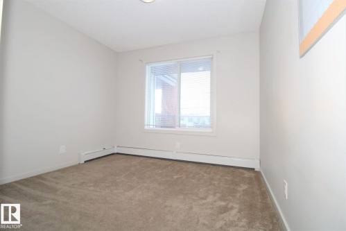 Spare room with light carpet and baseboard heating - 430 5515 7 Avenue, Edmonton, AB - Indoor Photo Showing Other Room