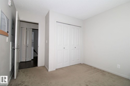 Unfurnished bedroom with light carpet, a closet, and a textured ceiling - 430 5515 7 Avenue, Edmonton, AB - Indoor Photo Showing Other Room