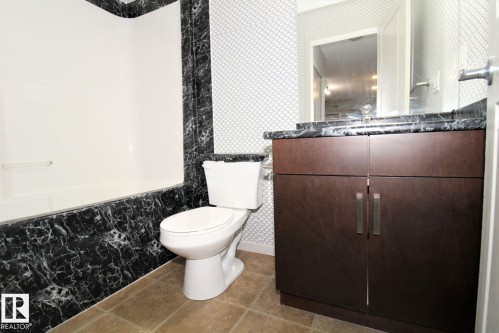 Bathroom featuring vanity, wallpapered walls, and light tile patterned flooring - 430 5515 7 Avenue, Edmonton, AB - Indoor Photo Showing Bathroom
