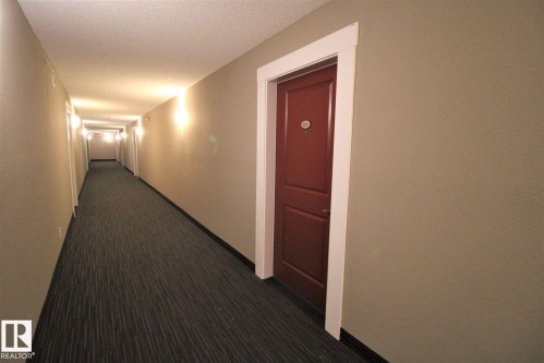Hallway featuring dark carpet and a textured ceiling - 430 5515 7 Avenue, Edmonton, AB - Indoor Photo Showing Other Room