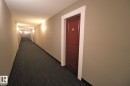 Hallway featuring dark carpet and a textured ceiling - 430 5515 7 Avenue, Edmonton, AB  - Indoor Photo Showing Other Room 
