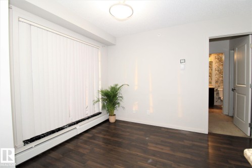 Spare room featuring a baseboard heating unit and dark wood-type flooring - 430 5515 7 Avenue, Edmonton, AB - Indoor Photo Showing Other Room
