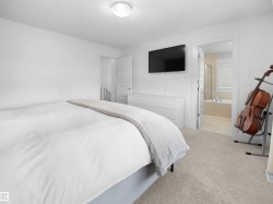 Bedroom with light colored carpet and connected bathroom - 