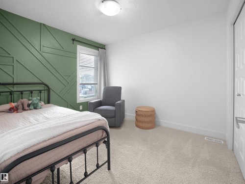 Carpeted bedroom with baseboards and a textured ceiling - 3387 Parker Loop, Edmonton, AB - Indoor Photo Showing Bedroom