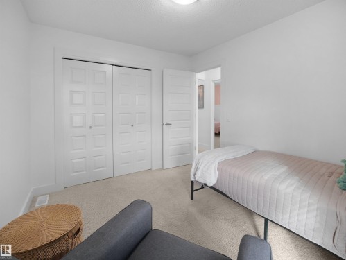 Carpeted bedroom featuring a textured ceiling and a closet - 3387 Parker Loop, Edmonton, AB - Indoor Photo Showing Bedroom