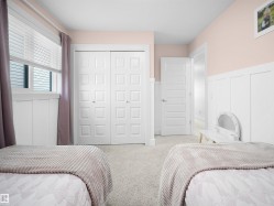 Carpeted bedroom with wainscoting, a decorative wall, and a closet - 
