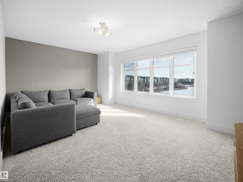 Carpeted living room with a textured ceiling and baseboards - 3387 Parker Loop, Edmonton, AB - Indoor Photo Showing Living Room