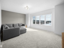 Carpeted living room with a textured ceiling and baseboards - 