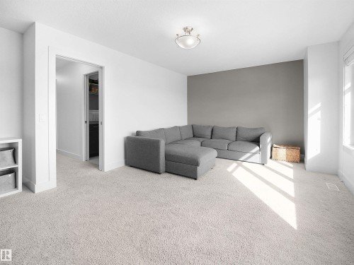 Living room featuring light carpet and baseboards - 3387 Parker Loop, Edmonton, AB - Indoor