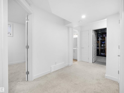 Unfurnished bedroom with a spacious closet, light carpet, connected bathroom, and recessed lighting - 3387 Parker Loop, Edmonton, AB - Indoor Photo Showing Other Room
