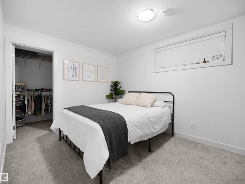 Bedroom with light colored carpet and a spacious closet - 3387 Parker Loop, Edmonton, AB - Indoor Photo Showing Bedroom