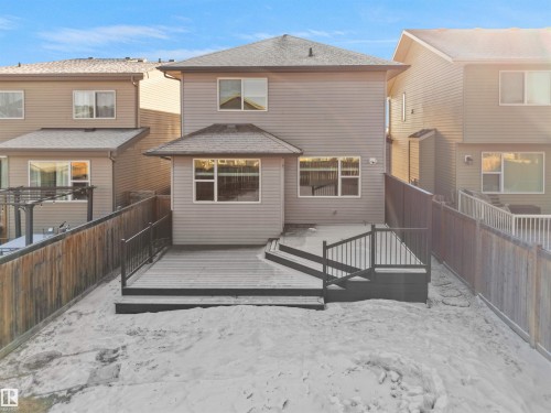 Rear view of house with a fenced backyard, a deck, and a shingled roof - 3387 Parker Loop, Edmonton, AB - Outdoor With Exterior