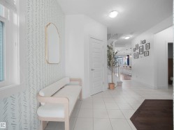 Hall with light tile patterned flooring and baseboards - 