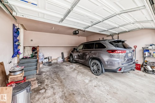 Spacious garage with a concrete floor, painted walls, and a white paneled garage door - 11532 9 Avenue, Edmonton, AB - Indoor Photo Showing Garage