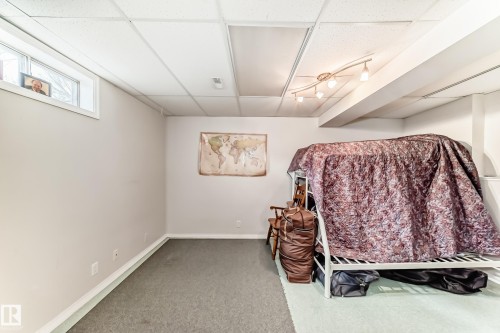 This room features neutral-toned walls, a drop ceiling, and track lighting - 11532 9 Avenue, Edmonton, AB - Indoor
