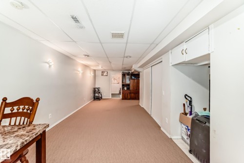 Spacious room featuring carpeting, light-colored walls, recessed lighting, and wall-mounted sconces - 11532 9 Avenue, Edmonton, AB - Indoor Photo Showing Other Room