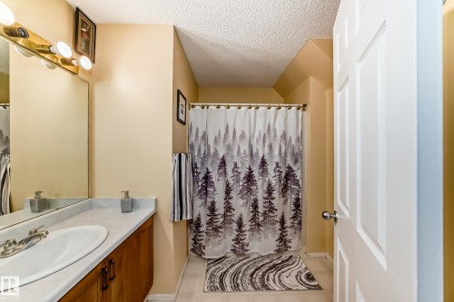 Bathroom featuring a vanity with a sink and mirror, and a shower with a curtain - 11532 9 Avenue, Edmonton, AB - Indoor Photo Showing Bathroom