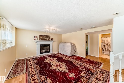 This versatile interior features hardwood flooring and a white tile fireplace - 11532 9 Avenue, Edmonton, AB - Indoor With Fireplace