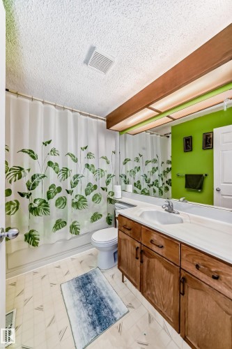 The bathroom features a vanity with a white countertop and a built-in sink, providing functional space - 11532 9 Avenue, Edmonton, AB - Indoor Photo Showing Bathroom