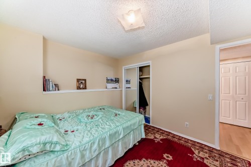 This room features a sliding door closet, a light-colored ceiling, and a wall shelf - 11532 9 Avenue, Edmonton, AB - Indoor Photo Showing Bedroom