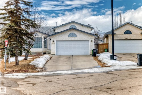 Exterior view featuring a light-colored facade, an attached garage, and a concrete driveway - 11532 9 Avenue, Edmonton, AB - Outdoor