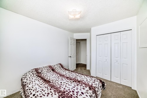 Bedroom featuring white walls, carpet flooring, a white bi-fold closet, and a white interior door - 11532 9 Avenue, Edmonton, AB - Indoor Photo Showing Bedroom
