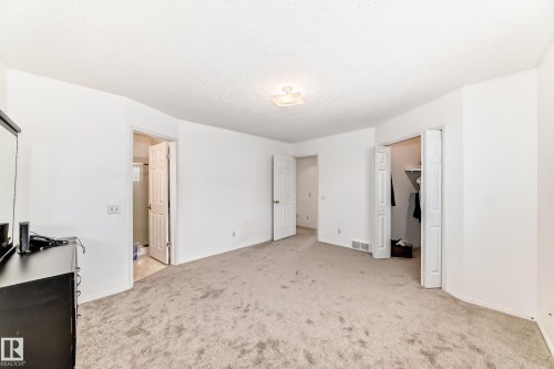 Well-proportioned room featuring light-colored carpeting, white walls, and a ceiling light fixture - 11532 9 Avenue, Edmonton, AB - Indoor Photo Showing Other Room