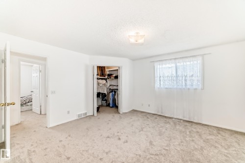 This room features light-colored carpeting, a window with sheer curtains, and a ceiling-mounted light fixture - 11532 9 Avenue, Edmonton, AB - Indoor Photo Showing Other Room