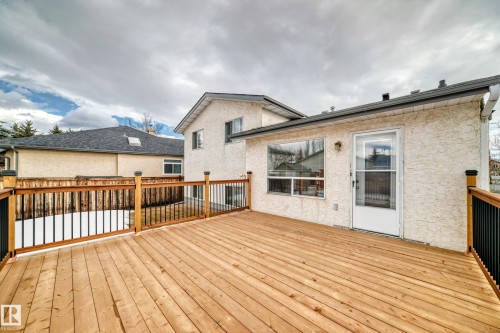 The property features an expansive outdoor deck with a wooden surface and railing, complemented by black metal balusters - 11532 9 Avenue, Edmonton, AB - Outdoor With Deck Patio Veranda With Exterior