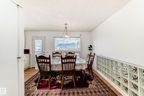 Dining area with a window, a white door, and a glass block wall feature - 11532 9 Avenue, Edmonton, AB - Indoor Photo Showing Dining Room