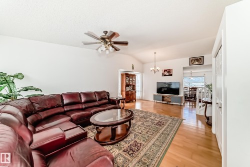 The living area features light wood flooring, a ceiling fan, and an elegant area rug - 11532 9 Avenue, Edmonton, AB - Indoor Photo Showing Living Room