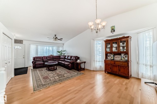 Bright living space with light wood flooring, a white vaulted ceiling, and a prominent bay window - 11532 9 Avenue, Edmonton, AB - Indoor
