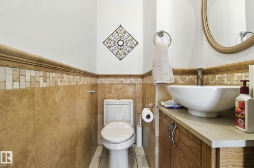 Bathroom featuring a wainscoted wall, vanity, tile walls, and light tile patterned flooring - 39 Grand Meadow Crescent, Edmonton, AB - Indoor Photo Showing Bathroom
