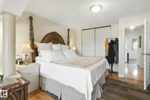 Bedroom featuring wood finished floors, a closet, a textured ceiling, and ornate columns - 39 Grand Meadow Crescent, Edmonton, AB - Indoor Photo Showing Bedroom