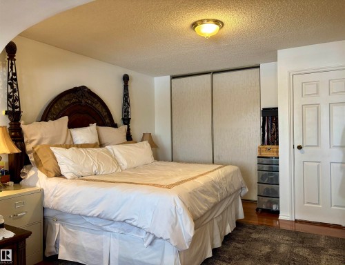 Bedroom featuring a closet, a textured ceiling, and dark wood finished floors - 39 Grand Meadow Crescent, Edmonton, AB - Indoor Photo Showing Bedroom