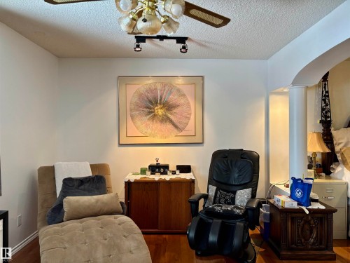 Sitting room featuring a ceiling fan, wood finished floors, a textured ceiling, arched walkways, and decorative columns - 39 Grand Meadow Crescent, Edmonton, AB - Indoor