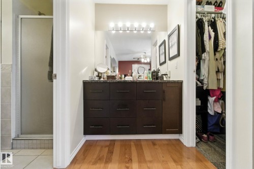 Bathroom featuring double vanity, a walk in closet, a stall shower, and light wood-style flooring - 39 Grand Meadow Crescent, Edmonton, AB - Indoor