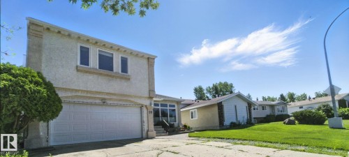 View of front of home with an attached garage, stucco siding, a front lawn, and concrete driveway - 39 Grand Meadow Crescent, Edmonton, AB - Outdoor