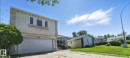 View of front of home with an attached garage, stucco siding, a front lawn, and concrete driveway - 39 Grand Meadow Crescent, Edmonton, AB  - Outdoor 