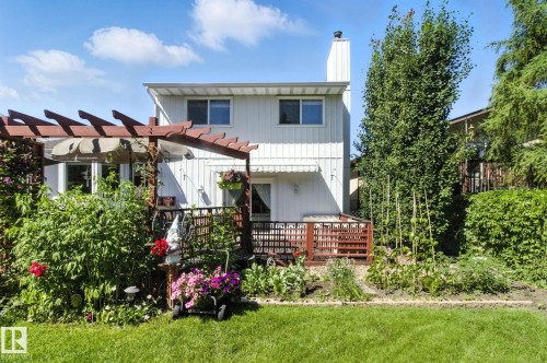 Back of property with a wooden deck, a chimney, a yard, and a pergola - 39 Grand Meadow Crescent, Edmonton, AB - Outdoor