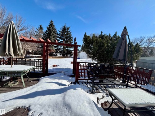 Snow covered deck with outdoor dining space and a storage unit - 39 Grand Meadow Crescent, Edmonton, AB - Outdoor