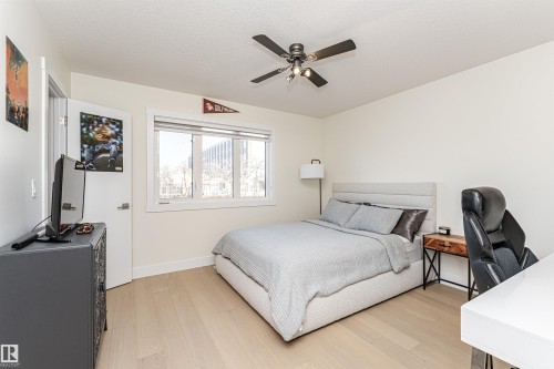 Bedroom featuring light wood-style floors, a desk, a ceiling fan, and a textured ceiling - 2 11569 University Avenue, Edmonton, AB - Indoor Photo Showing Bedroom