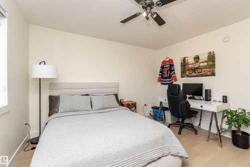 Bedroom featuring an office area, light wood-style flooring, and a ceiling fan - 2 11569 University Avenue, Edmonton, AB - Indoor Photo Showing Bedroom