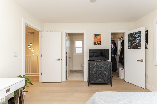 Bedroom featuring light wood-style floors, a walk in closet, and ceiling fan - 2 11569 University Avenue, Edmonton, AB - Indoor Photo Showing Bedroom