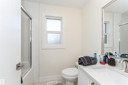 Bathroom featuring vanity, combined bath / shower with glass door, and light wood-type flooring - 2 11569 University Avenue, Edmonton, AB - Indoor Photo Showing Bathroom