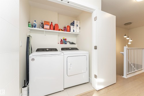 Laundry area featuring washer and clothes dryer and light wood-style floors - 2 11569 University Avenue, Edmonton, AB - Indoor Photo Showing Laundry Room