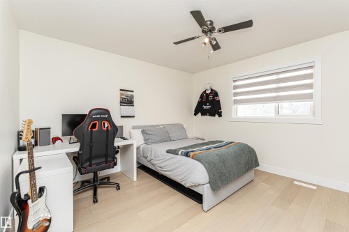 Bedroom featuring an office area, light wood finished floors, and a ceiling fan - 2 11569 University Avenue, Edmonton, AB - Indoor Photo Showing Bedroom